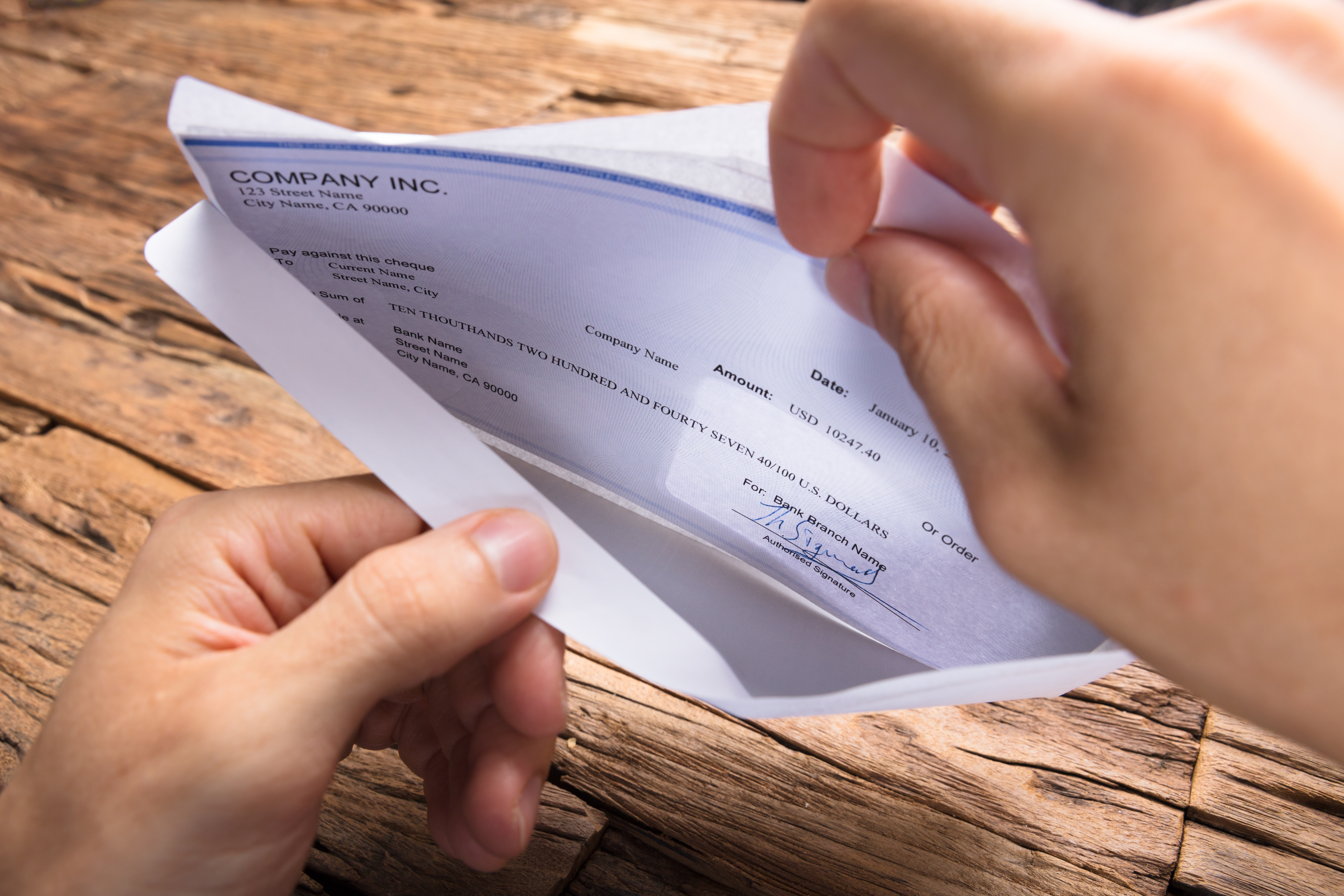 Cropped,Hands,Of,Businessman,Opening,Envelope,With,Paycheck